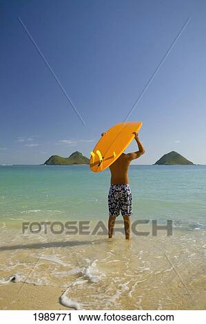 Surfer Walking Into The Water From The Beach With Board Over His Head. View Large Photo Image Stock Image - Surfer Walking Into The Water From The Beach With Board Over His Head.. Fotosearch