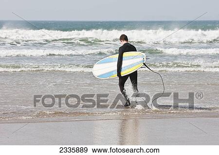 Stock Photo - Surfers On Newgale Beach; Pembrokeshire Coast Path, Wales, United Kingdom. Fotosearch