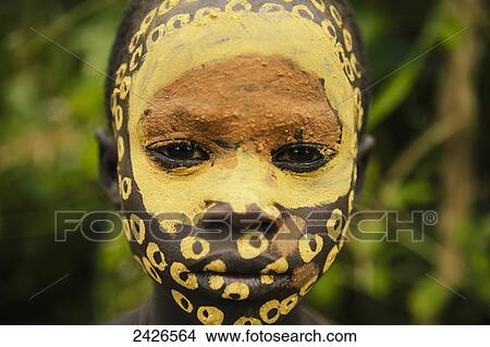 Picture - Surma child with face painted with pigment made from powdered coloured stones, Omo region, Southwest Ethiopia; Kibish, Ethiopia. Fotosearch