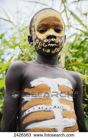 Surma child with face painted with pigment made from powdered coloured stones, Omo region, Southwest Ethiopia; Kibish, Ethiopia View Large Photo Image Stock Image - Surma child with face painted with pigment made from powdered coloured stones, Omo region, Southwest Ethiopia; Kibish, Ethiopia. Fotosearch