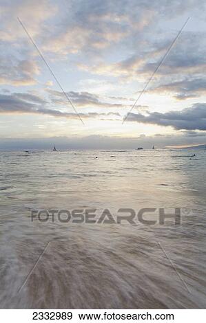 Stock Photo - Sweeping skies and moving water at sunset; Waikiki, Oahu, Hawaii, United States of America. Fotosearch