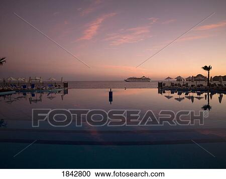 Swimming Pool In Holiday Resort At Dusk, Cruise Ship In Background; Los Cabos, Mexico View Large Photo Image Stock Image - Swimming Pool In Holiday Resort At Dusk, Cruise Ship In Background; Los Cabos, Mexico. Fotosearch