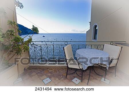 Table and two chairs on a patio overlooking the Amalfi Coast; Positano, Italy View Large Photo Image Picture - Table and two chairs on a patio overlooking the Amalfi Coast; Positano, Italy. Fotosearch