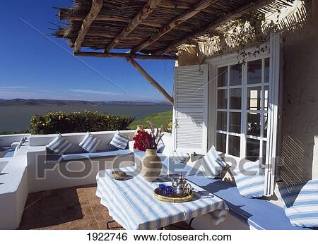 Stock Photograph - Table On Patio Outside House Near Coast. Fotosearch