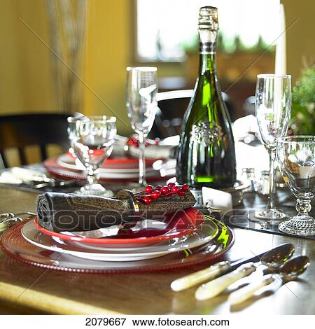 Stock Photo - Table Setting With Red And White Plates, Red Berries On Napkin Ring And Champagne Bottle Victoria Bc. Fotosearch