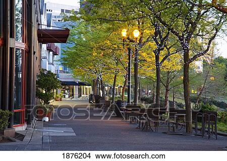 stock photo of tables and chairs along a walkway in the city