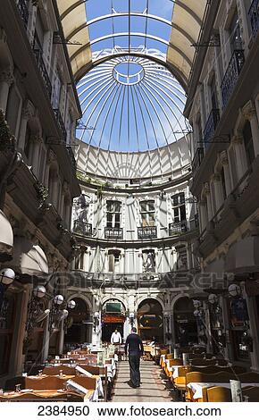Tables and chairs inside the corridor of a building with a glass dome ceiling; Istanbul, Turkey View Large Photo Image Stock Image - Tables and chairs inside the corridor of a building with a glass dome ceiling; Istanbul, Turkey. Fotosearch