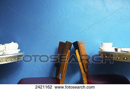 Stock Image - Tables and wooden chairs in a cafe; London, England. Fotosearch