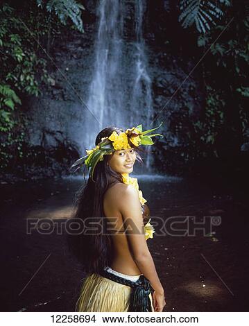 Picture - Tahitian woman wearing grass skirt bathing in waterfall; Tahiti. Fotosearch