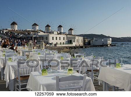 Taverna tables set for dinner along the seafront in the Little Venice area; Mykonos Town, Mykonos, Cyclades, Greek Islands, Greece View Large Photo Image Stock Photo - Taverna tables set for dinner along the seafront in the Little Venice area; Mykonos Town, Mykonos, Cyclades, Greek Islands, Greece. Fotosearch
