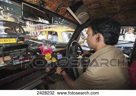 Stock Image - Taxi driver waiting in traffic; Mumbai, India. Fotosearch