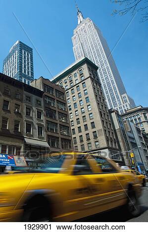 Taxi Passing In Front Of The Empire State Building, Manhattan, New York, Usa View Large Photo Image Stock Image - Taxi Passing In Front Of The Empire State Building, Manhattan, New York, Usa. Fotosearch