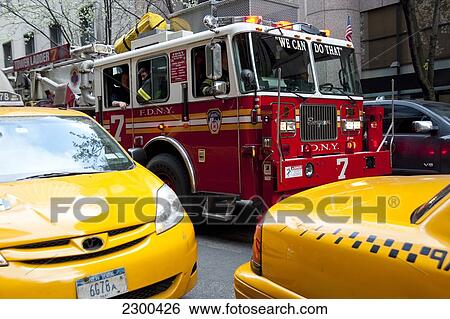 Stock Photograph - Taxis And Fire Brigade Truck In Midtown Manhattan, New York, Usa. Fotosearch