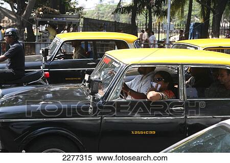 Stock Photography - Taxis in traffic jam with woman covering her mouth with handkerchief in an attempt to avoid pollution while stuck in traffic; Mumbai, Maharashtra State, India. Fotosearch