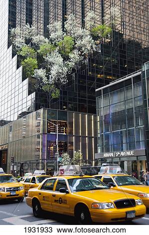 Stock Image - Taxis Passing By The Trump Tower In 5Th Avenue, Midtown Manhattan, New York, Usa. Fotosearch
