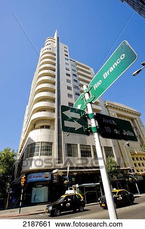 Stock Image - Taxis Passing In Front Of Edificio Lapido, Tribuna Popular Palace, Historical Building Built In 1929-30, Expresionism Style, Montevideo, Uruguay, South America. Fotosearch