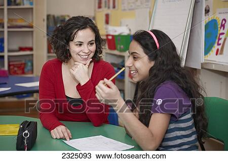 Teacher Helping Grade 5 Female Student In Classroom, Toronto, Ontario, Canada View Large Photo Image Stock Image - Teacher Helping Grade 5 Female Student In Classroom, Toronto, Ontario, Canada. Fotosearch