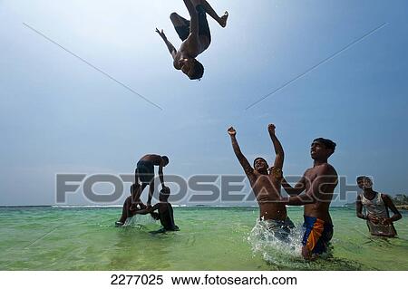 Teenage boys throwing each other in the air doing backflips in shallow water, Thalpe, near Unawatuna; Sri Lanka View Large Photo Image Stock Photography - Teenage boys throwing each other in the air doing backflips in shallow water, Thalpe, near Unawatuna; Sri Lanka. Fotosearch