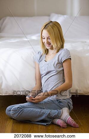 Stock Photo - Teenage Girl Listening To Music Leaning On Bed, Bradford, Ontario. Fotosearch