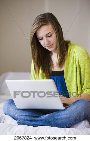Teenage Girl Sitting On Bed Using Laptop, Bradford, Ontario View Large Photo Image Picture - Teenage Girl Sitting On Bed Using Laptop, Bradford, Ontario. Fotosearch