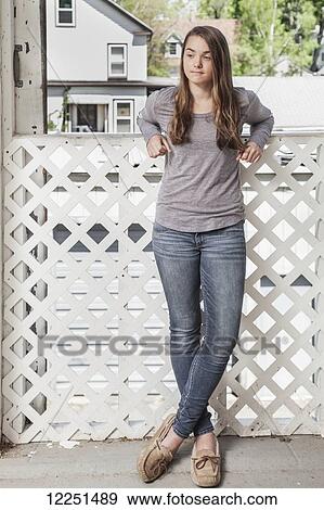 Teenage girl standing against a fence; Connecticut, United States of America View Large Photo Image Stock Photo - Teenage girl standing against a fence; Connecticut, United States of America. Fotosearch