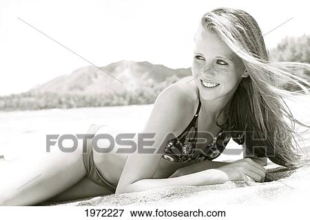 Stock Photo - Teenage Girl With Freckles And Red Hair Lays In The Sand At The Beach.. Fotosearch
