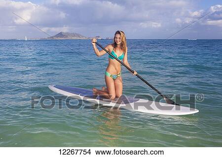 Picture - Teenage girl with her paddle board; Kailua, Island of Hawaii, Hawaii, United States of America. Fotosearch