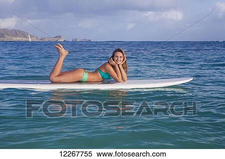 Stock Photography - Teenage girl with her paddle board; Kailua, Island of Hawaii, Hawaii, United States of America. Fotosearch