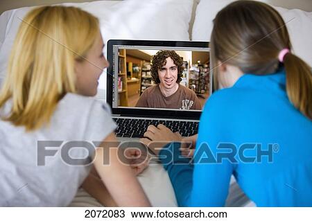 Teenage Girls Lying On Bed Video Chatting With Friend In A Library, Bradford, Ontario View Large Photo Image Stock Image - Teenage Girls Lying On Bed Video Chatting With Friend In A Library, Bradford, Ontario. Fotosearch