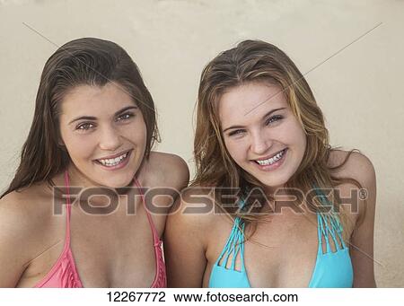Stock Image - Teenage sisters at the beach; Kailua, Island of Hawaii, Hawaii, United States of America. Fotosearch