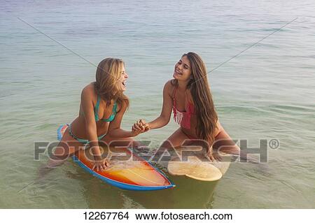 Picture - Teenage sisters with their surfboards; Kailua, Island of Hawaii, Hawaii, United States of America. Fotosearch