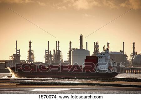 Teesside, England; A Boat In The Water With A Refinery In The Background Along The Shore View Large Photo Image Picture - Teesside, England; A Boat In The Water With A Refinery In The Background Along The Shore. Fotosearch