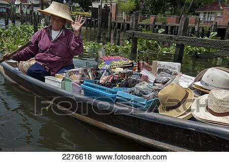 Stock Photo - Thai woman in small river boat selling goods; Bangkok, Thailand. Fotosearch