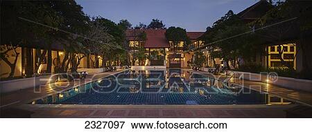 Stock Photo - Thailand, An outdoor swimming pool in the evening at the Horizon Village Resort and Convention Center; Chiang Mai. Fotosearch
