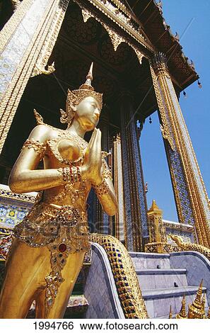 Stock Photograph - Thailand, Bangkok, Grand Palace, Wat Phra Keo, Close-Up Gold Statue Mythical Creature Guarding Temple Background. Fotosearch
