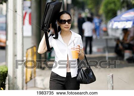 Stock Photography - Thailand, Bangkok, Thai Woman In Business Clothes Walking Down Street.. Fotosearch