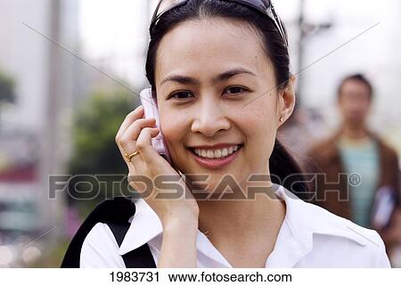 Stock Image - Thailand, Bangkok, Thai Woman On Cell Phone.. Fotosearch