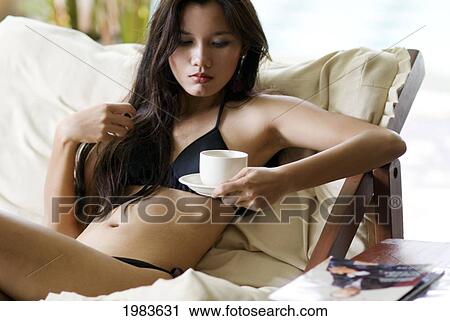 Stock Image - Thailand, Bangkok, Thai Woman Relaxing In Spa Like Setting.. Fotosearch
