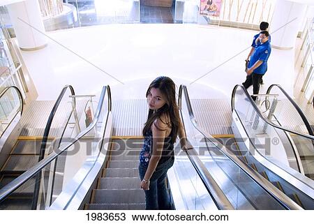 Thailand, Bangkok, Thai Woman Riding An Escalator. View Large Photo Image Stock Image - Thailand, Bangkok, Thai Woman Riding An Escalator.. Fotosearch
