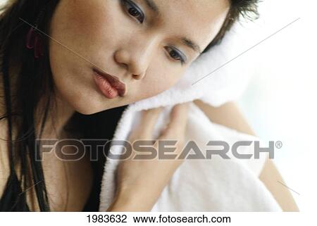 Stock Image - Thailand, Bangkok, Thai Woman Toweling Face Dry.. Fotosearch