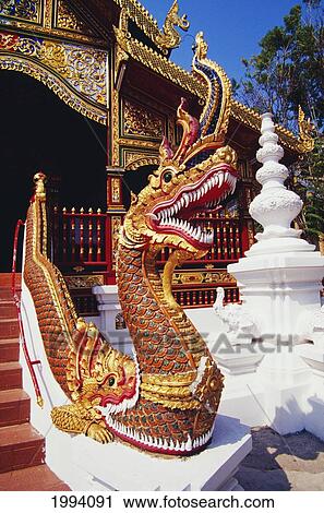 Stock Image - Thailand, Chiang Rai, Wat Mung Muang, Protective Serpent (Naga) Staue Guards Temple Entrance.. Fotosearch