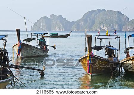Stock Photography - Thailand, Koh Phi Phi, Longtail boats along the shoreline, Mountains in distance.. Fotosearch