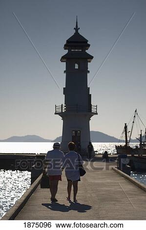 Thailand; People Walking Out On A Pier Towards A Lighthouse View Large Photo Image Stock Photograph - Thailand; People Walking Out On A Pier Towards A Lighthouse. Fotosearch
