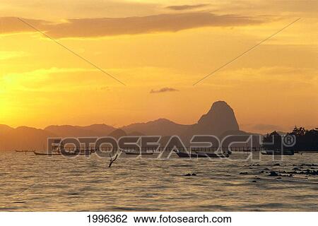 Thailand, Phangna Bay, Boats Anchored, Pier And Mountains At Sunset Golden Orange Sky View Large Photo Image Stock Image - Thailand, Phangna Bay, Boats Anchored, Pier And Mountains At Sunset Golden Orange Sky. Fotosearch