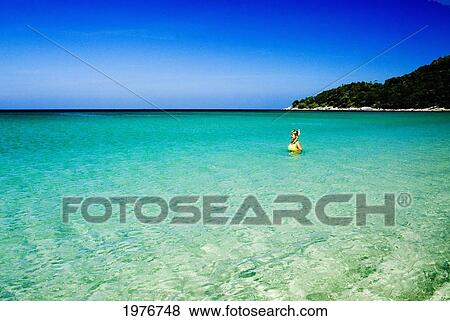 Stock Photo - Thailand, Phuket, Karon Beach, Woman With Mask And Snorkel In Bright Clear Tropical Water.. Fotosearch