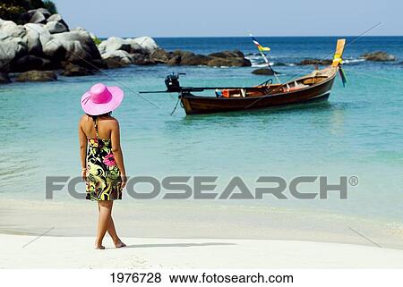 Stock Photo - Thailand, Phuket, Kata Noi, Woman In Colorful Dress And Hat On Tropical Blue Water Beach.. Fotosearch