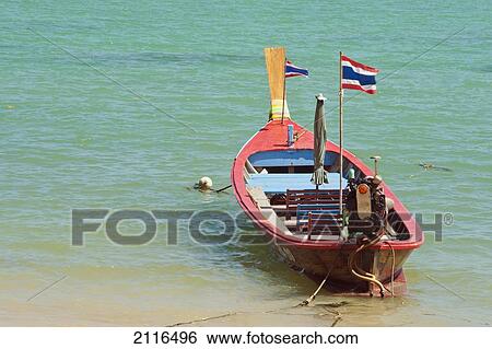Stock Photograph - Thailand, Phuket, Rawaii Beach, Close up of longtail boats along the in water.. Fotosearch