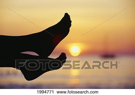 Thailand, Phuket, Silhouette Of Feet In Front Of A Sunset Over The Ocean. View Large Photo Image Stock Image - Thailand, Phuket, Silhouette Of Feet In Front Of A Sunset Over The Ocean.. Fotosearch