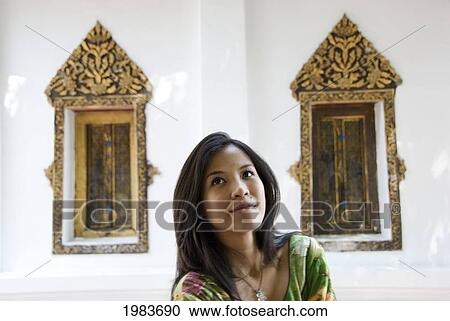 Stock Image - Thailand, Portrait of woman in temple; Bangkok. Fotosearch
