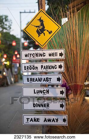 Stock Photography - Thailand, Post with various signs for coffee shop and sign with witch on broom; Pai. Fotosearch